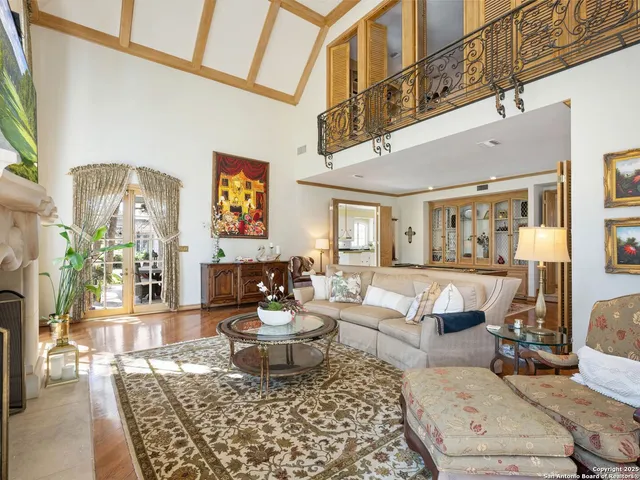 a large living room with stainless steel appliances furniture a fireplace and a large window