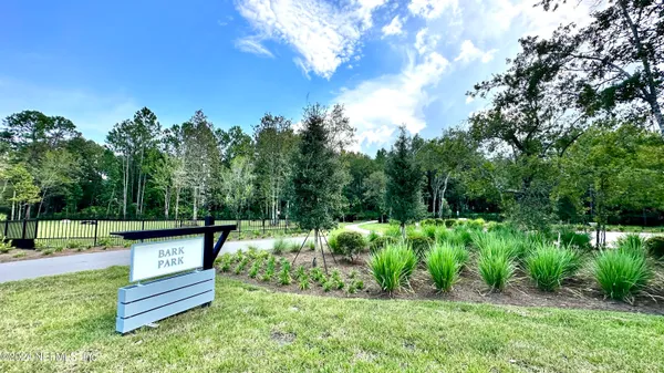 a view of a bench in the garden near a lake