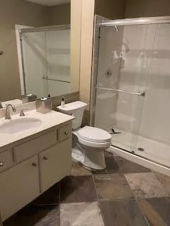 a bathroom with a sink a toilet and shower