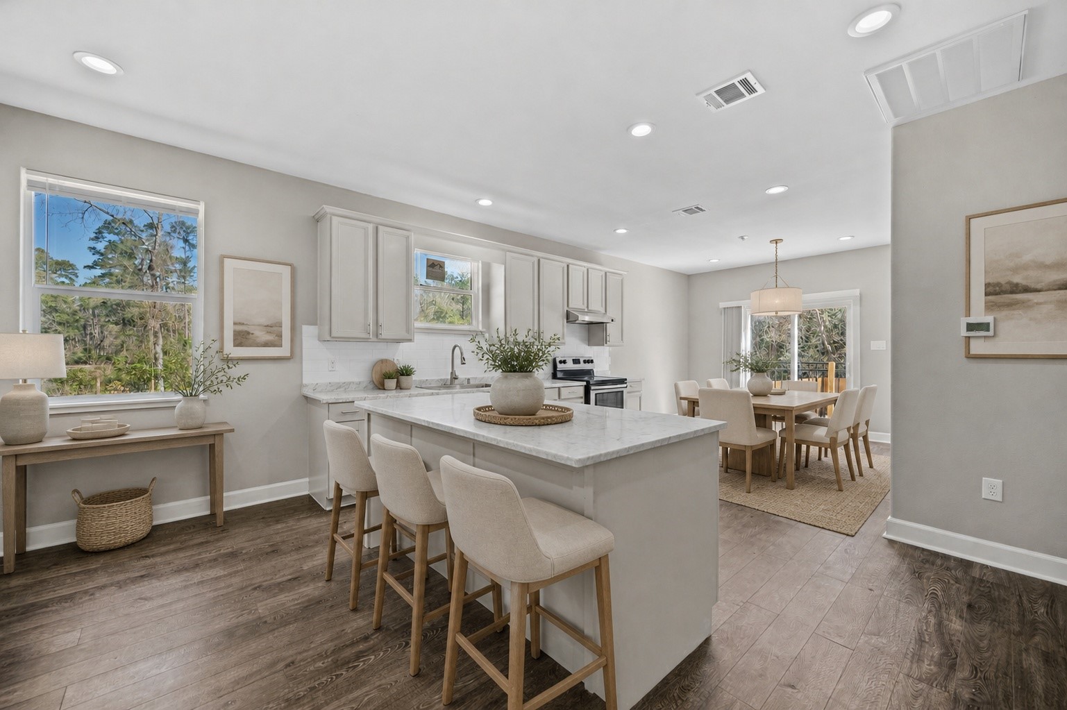 a kitchen with a dining table chairs and white cabinets