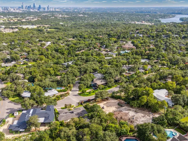 an aerial view of residential houses with outdoor space and trees