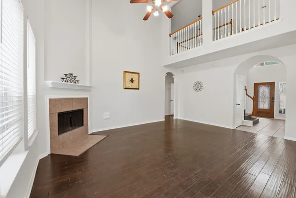 a view of a livingroom with wooden floor a fireplace and windows