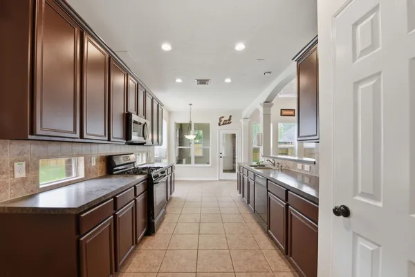 a large kitchen with stainless steel appliances granite countertop a sink stove and cabinets