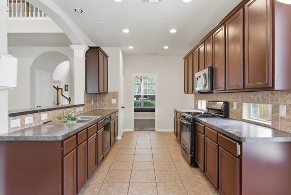 a large kitchen with kitchen island granite countertop a stove and a sink