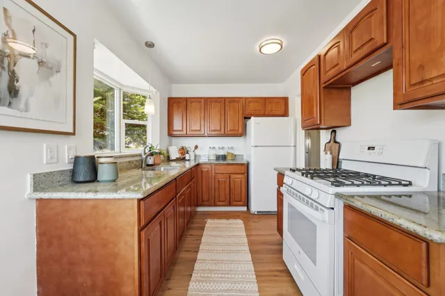 a kitchen with stainless steel appliances granite countertop a stove a sink dishwasher and a refrigerator