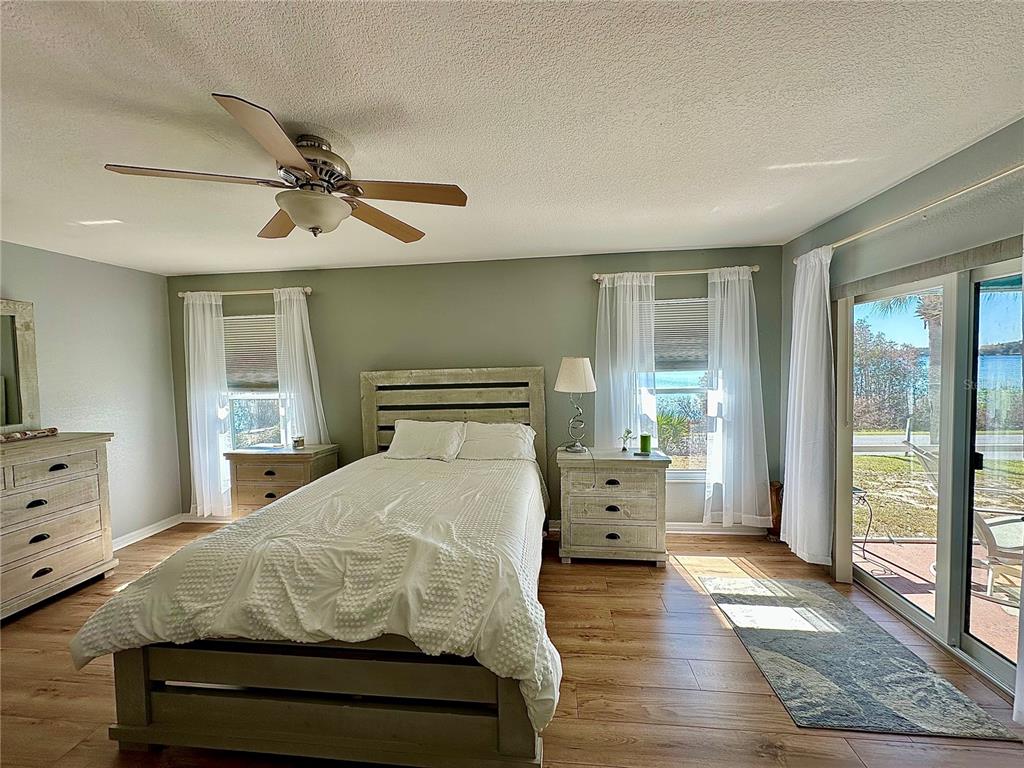 802 Marcia Loop Winter Haven, FL 33884 - Photo 8 of 48 a bedroom with a large bed and wooden floor