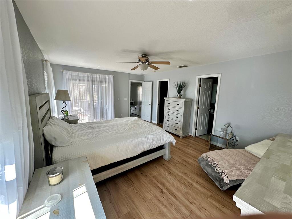 802 Marcia Loop Winter Haven, FL 33884 - Photo 9 of 48 a bedroom with a large bed and a chandelier
