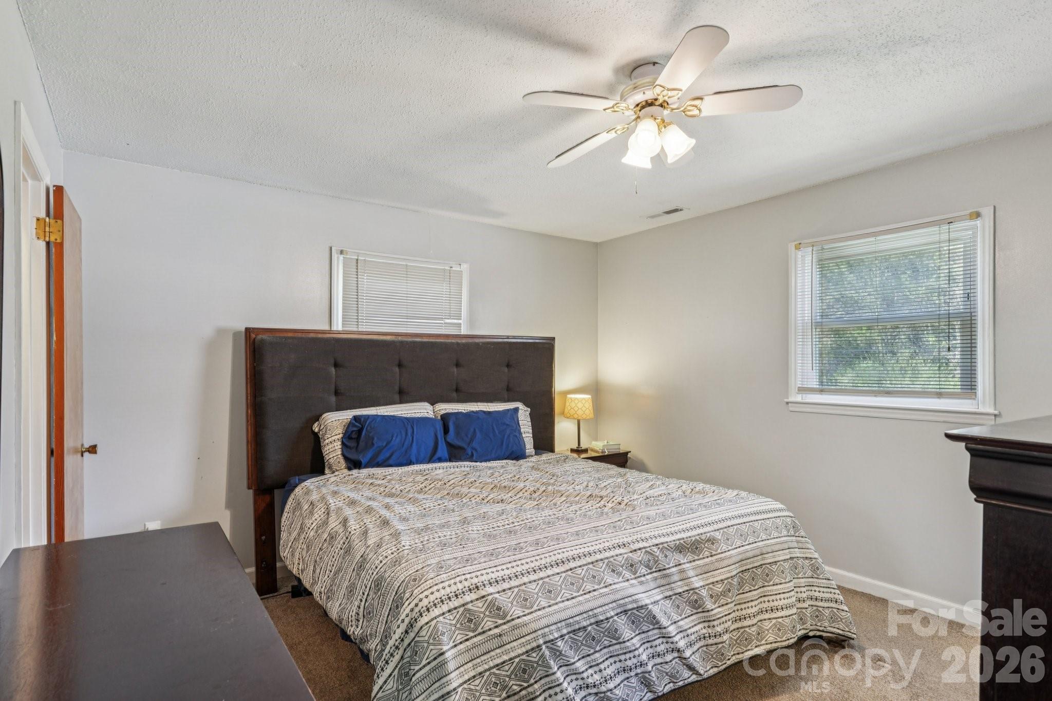 660 South Peace Haven Road Winston-Salem, NC 27103 - Photo 15 of 43 a bedroom with a bed and a chandelier