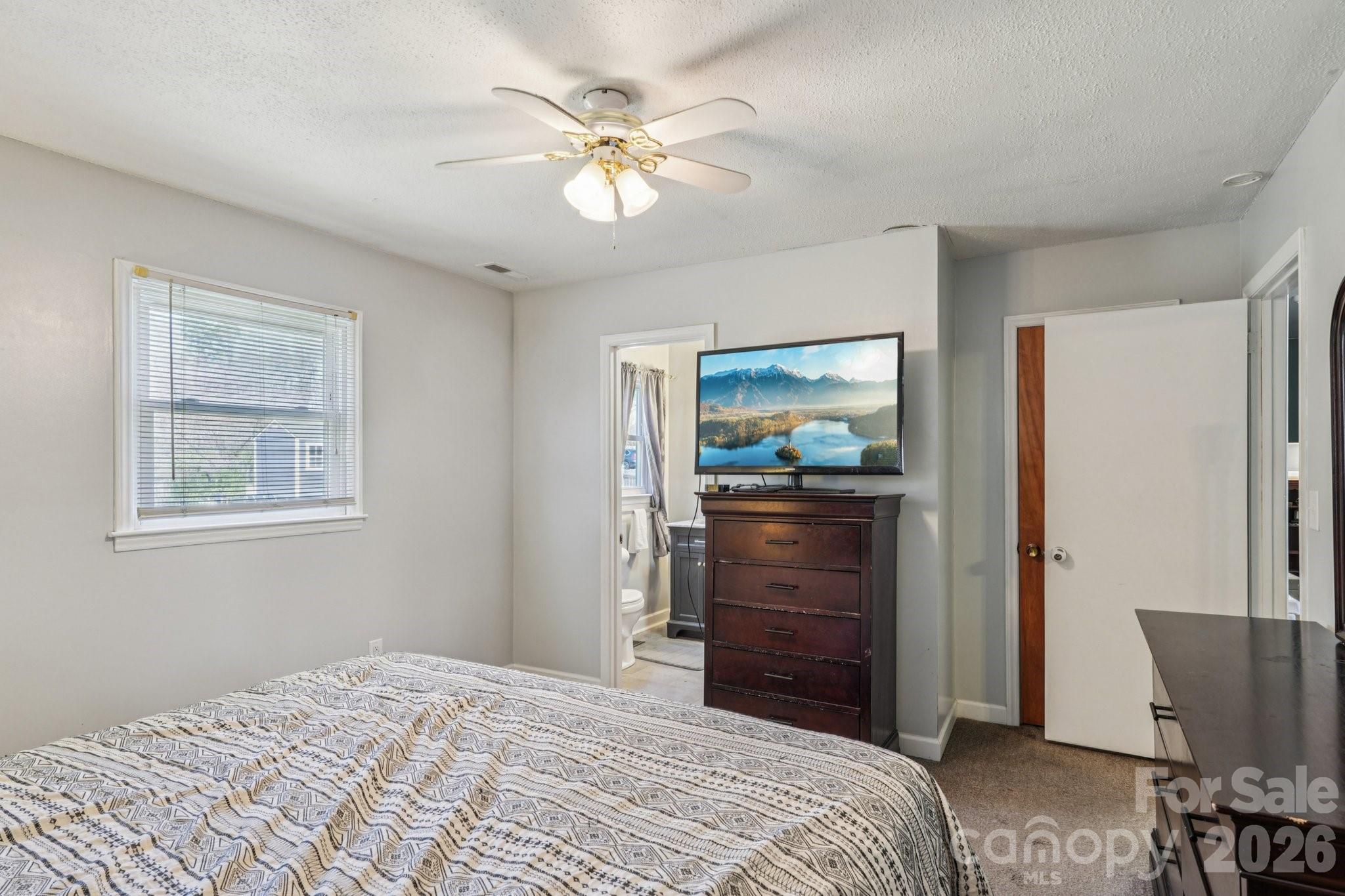 660 South Peace Haven Road Winston-Salem, NC 27103 - Photo 16 of 43 a bedroom with a bed and a chandelier