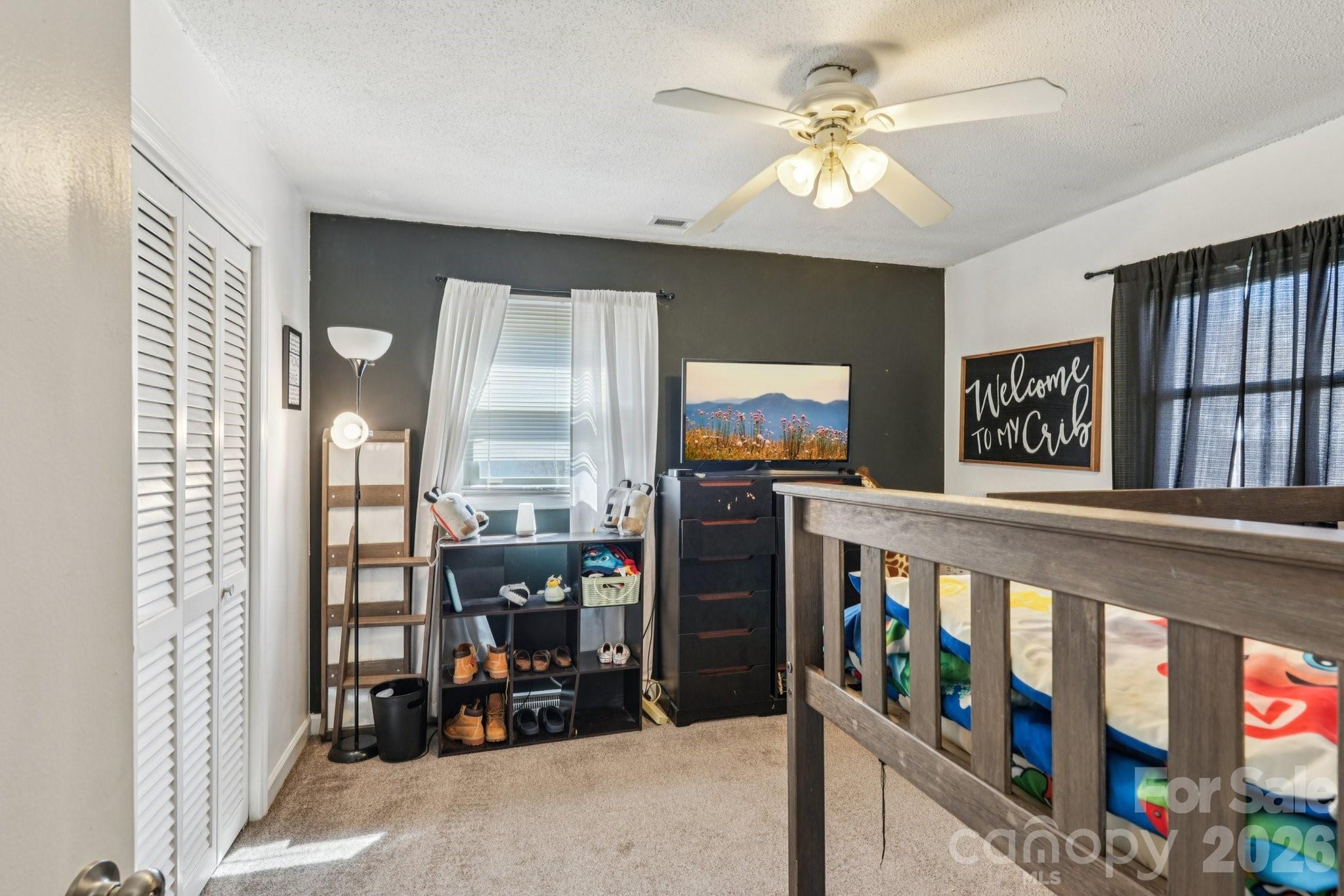 660 South Peace Haven Road Winston-Salem, NC 27103 - Photo 22 of 43 a living room with furniture a flat screen tv and a floor to ceiling window