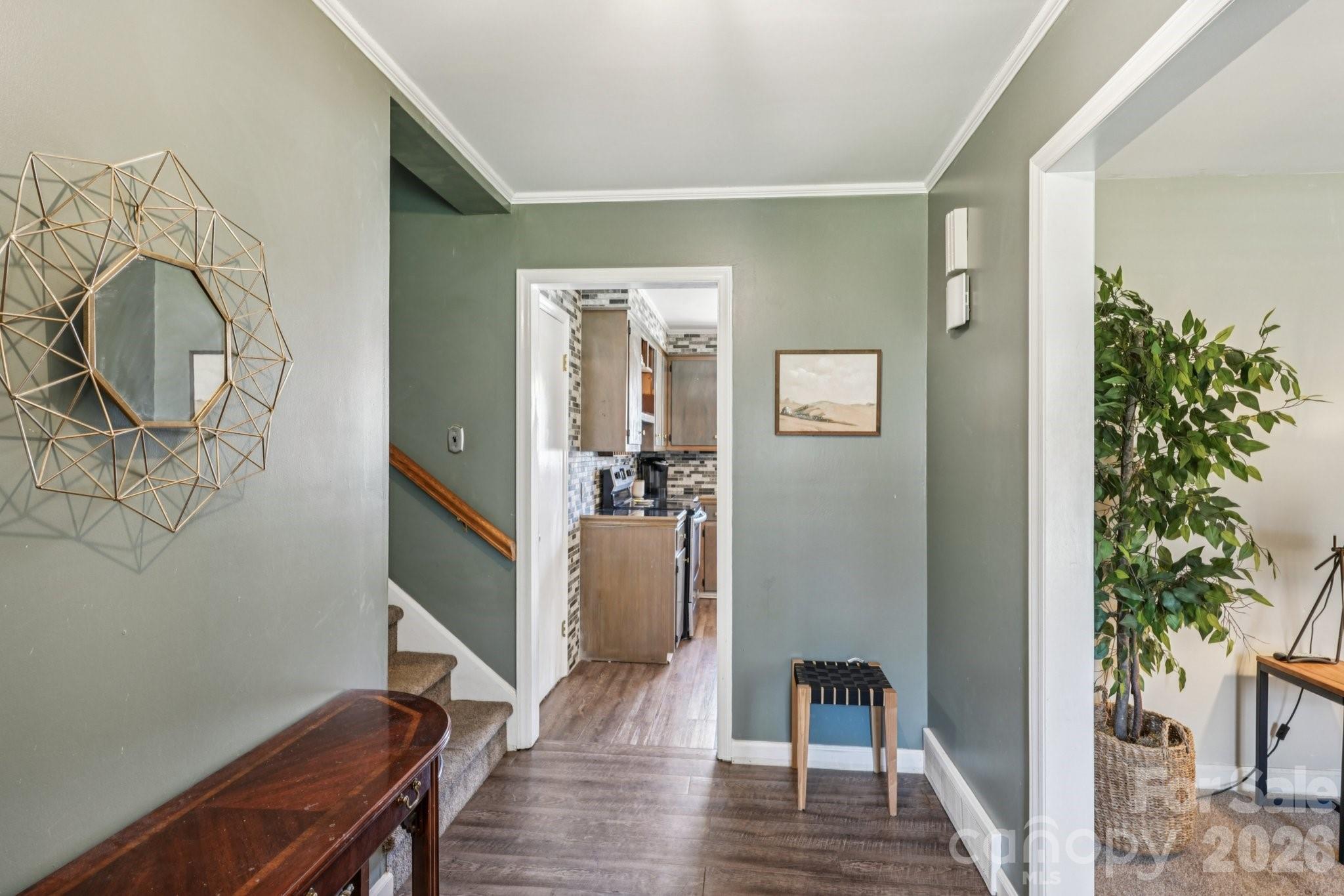 660 South Peace Haven Road Winston-Salem, NC 27103 - Photo 4 of 43 a view of a hallway with wooden floor and a potted plant