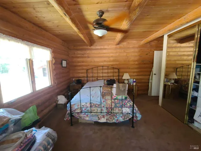 a bed sitting in a spacious bedroom next to a window