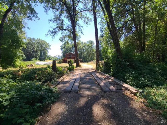 a view of a yard with table and chairs under an umbrella