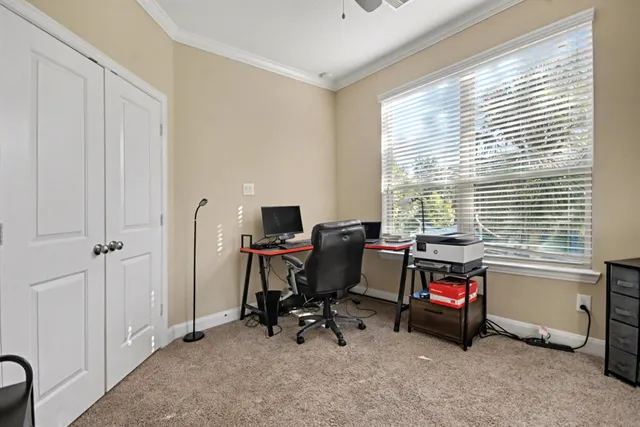 a view of a workspace with furniture and a window