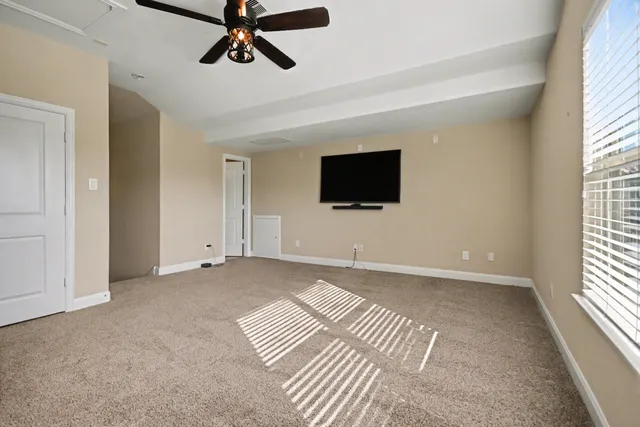 a view of an empty room with a window and a flat screen tv