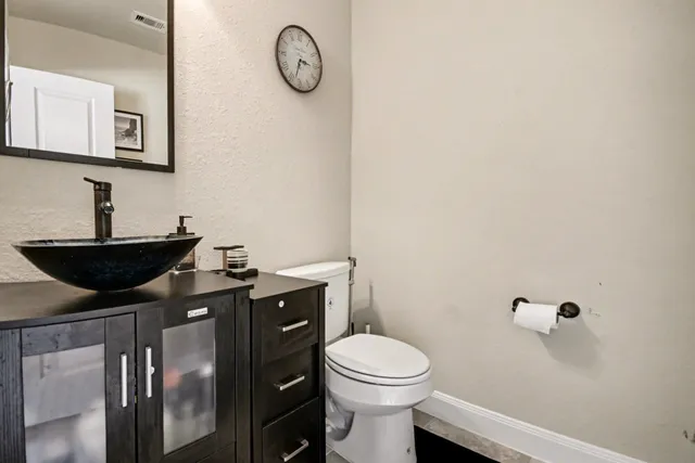 a bathroom with a toilet sink vanity and mirror