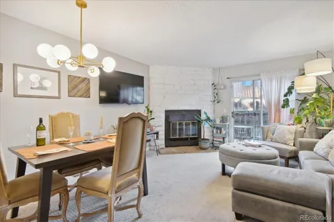 a living room with furniture a fireplace and a chandelier