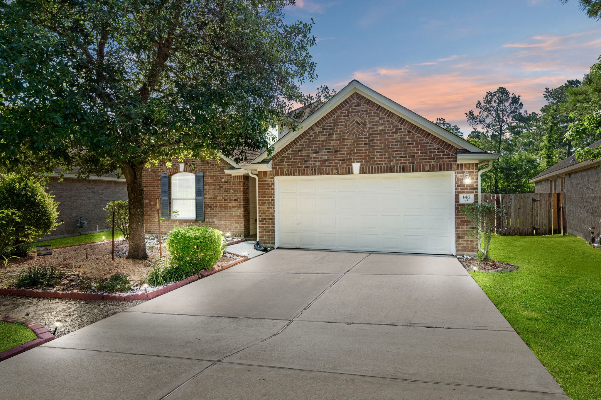 Welcome to 146 S Star Ridge Circle, a charming brick home with a two-car garage, set in a serene neighborhood. The front yard features mature trees and landscaped flower beds. A spacious driveway and well-maintained lawn complete the curb appeal.