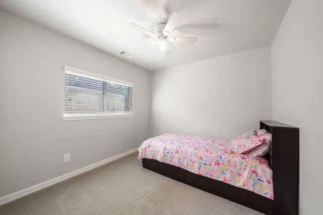 a bedroom with a bed and a chandelier fan