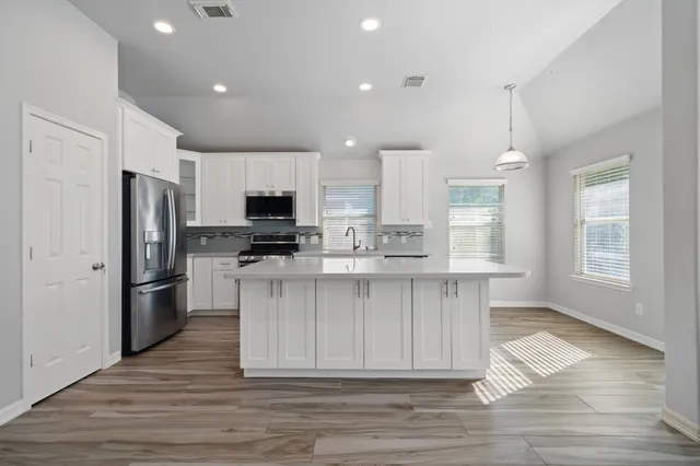 a kitchen with stainless steel appliances a refrigerator stove microwave and cabinets