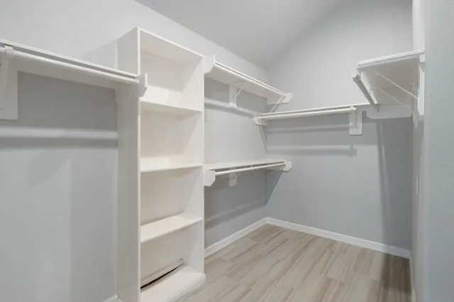 a view of walk in closet with empty racks