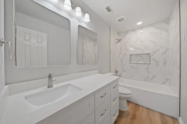 a bathroom with a tub sink and mirror