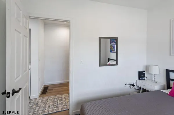 a bedroom with a bed and a lamp on dresser