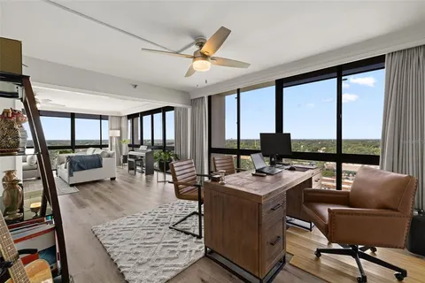 a bedroom with a balcony a bed and a large window