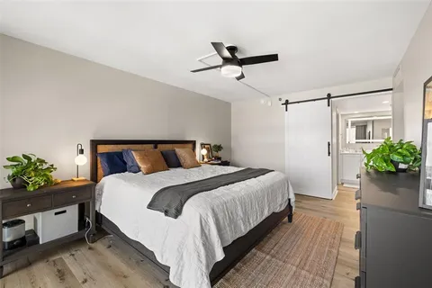 a bedroom with a bed and a painting on the wall