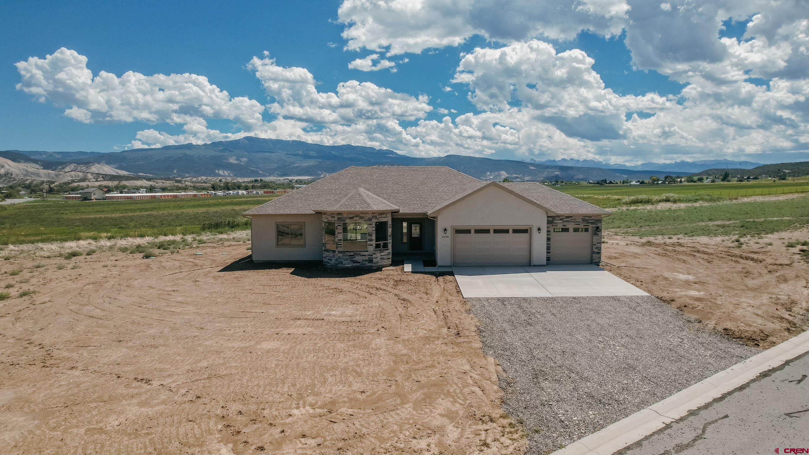a front view of a house with a yard and lake view