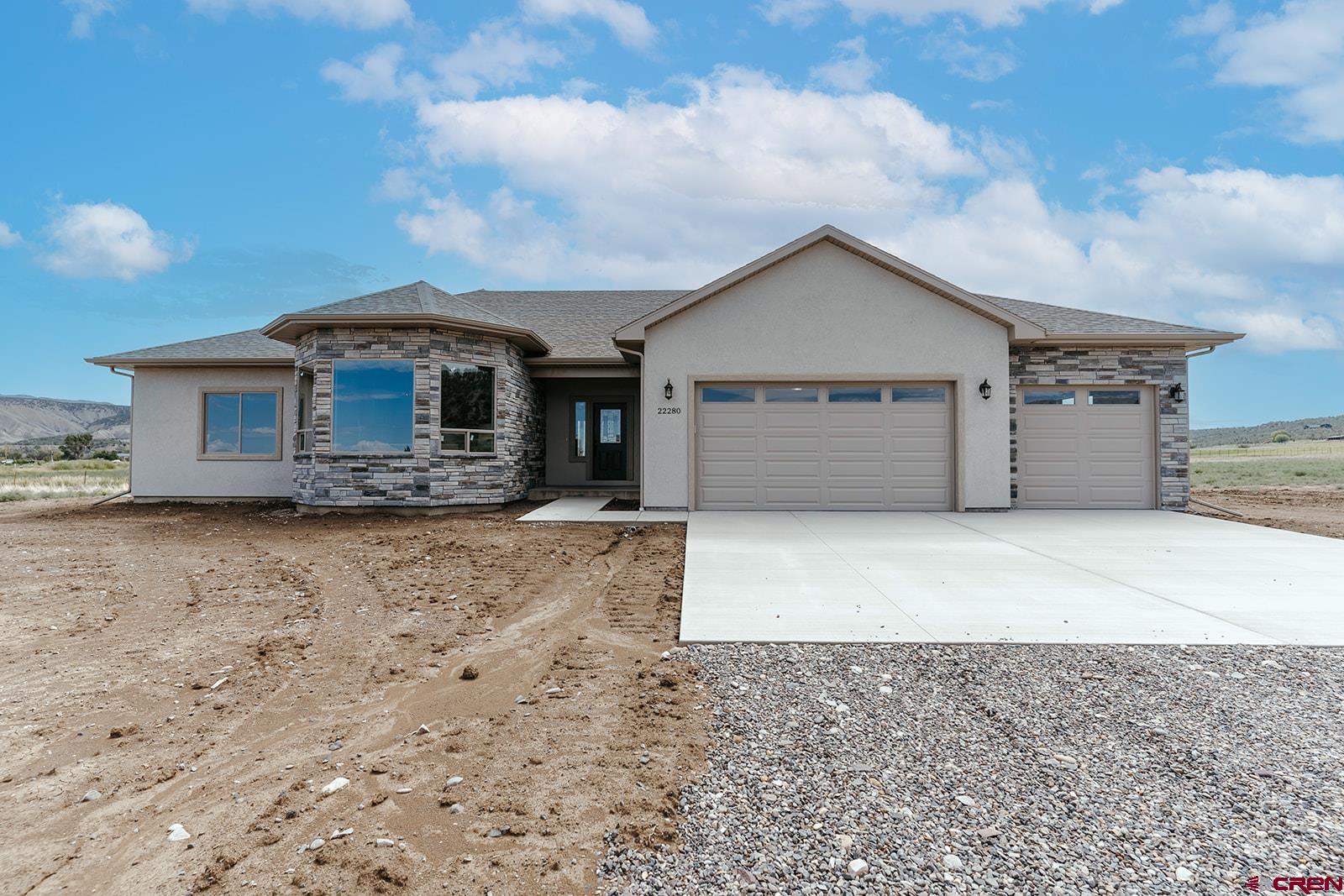22280 6845 Road Montrose, CO 81403 - Photo 2 of 34 a front view of a house with a yard and garage