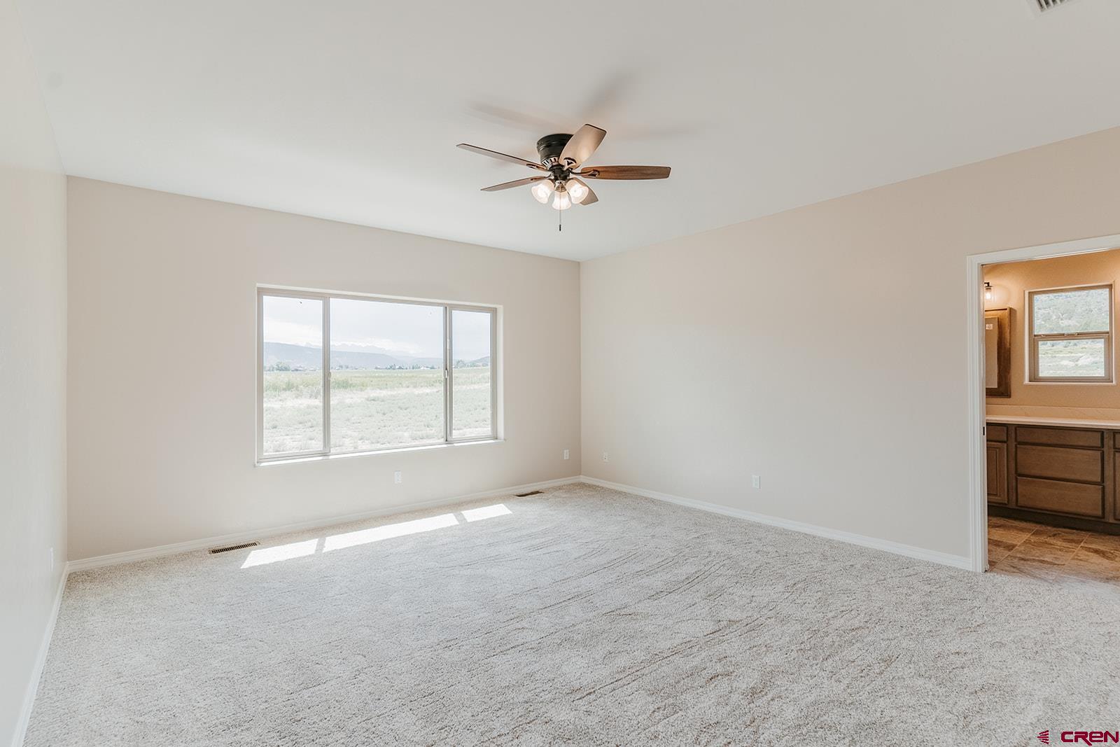 22280 6845 Road Montrose, CO 81403 - Photo 10 of 34 an empty room with windows and fan