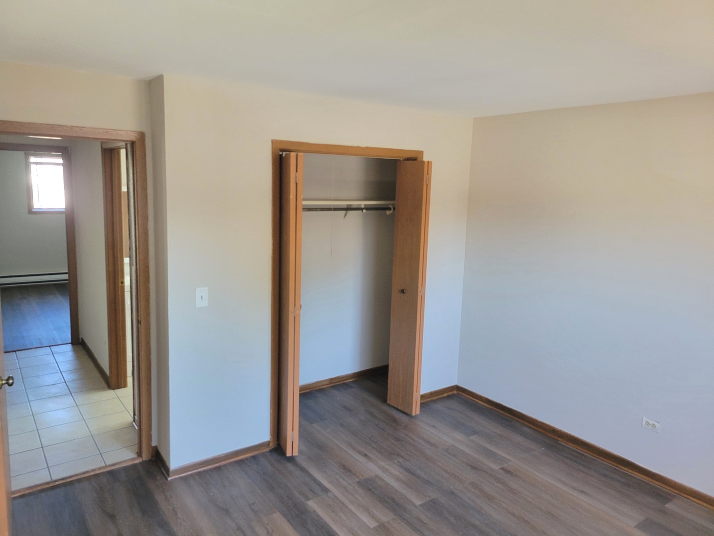 1257 Harding Avenue, Unit A2 Des Plaines, IL 60016 - Photo 7 of 9 a view of an empty room with wooden floor and a window