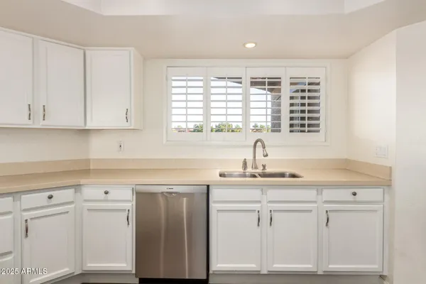 a kitchen with white cabinets and white appliances