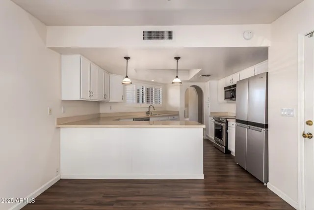 a kitchen with stainless steel appliances granite countertop a sink a stove and refrigerator