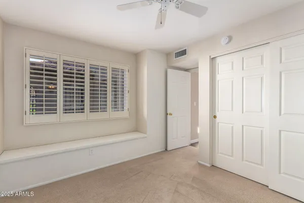 a view of empty room with windows and wardrobe