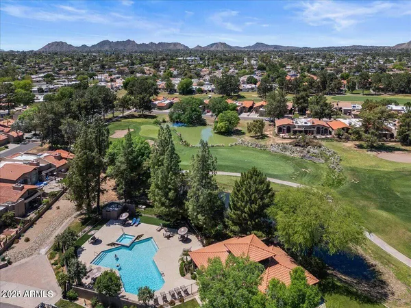 an aerial view of residential houses with outdoor space and trees