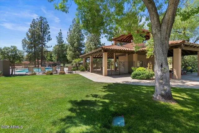 a view of an house with backyard and a tree