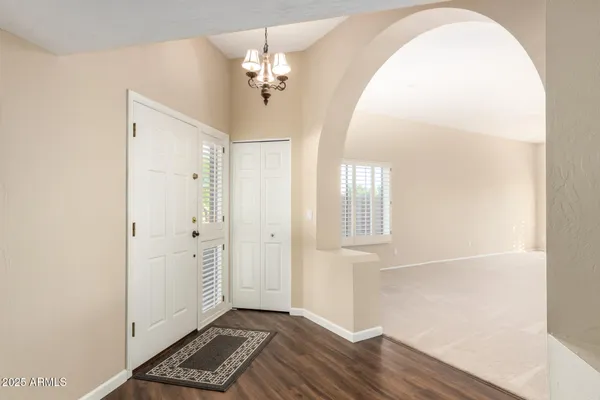 wooden floor in an entryway with a window