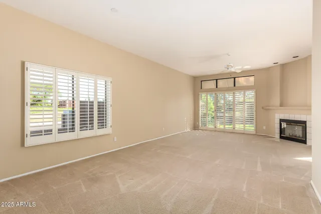 a view of an empty room with a fireplace and a window