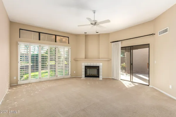 a view of an empty room with a fireplace and a window