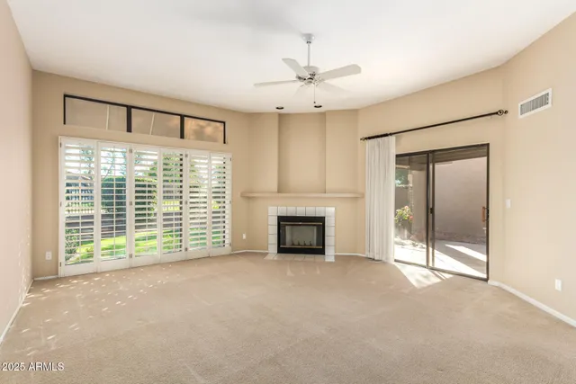 a view of an empty room with a fireplace and a window