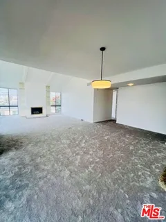 a view of an empty room with a kitchen