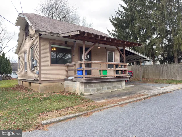 a view of house with a yard and sitting area