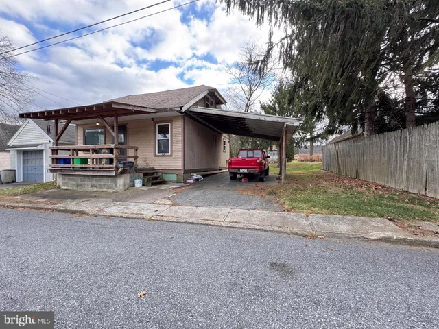 a view of a house with a yard and parking