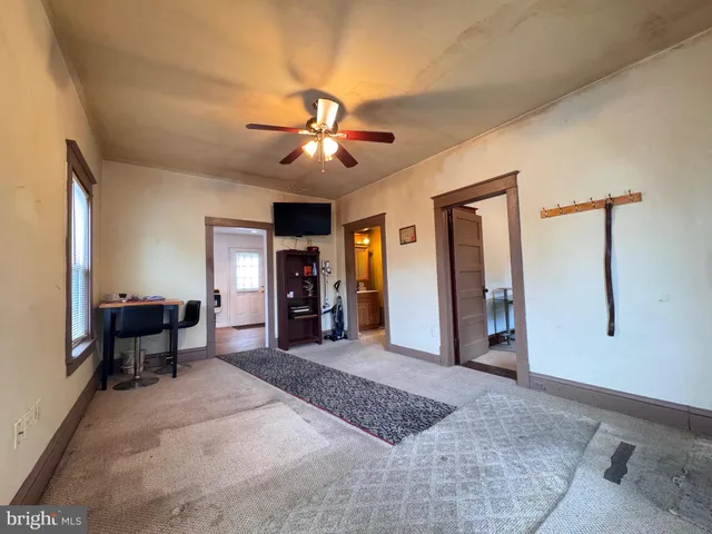 a view of a livingroom with furniture and a ceiling fan
