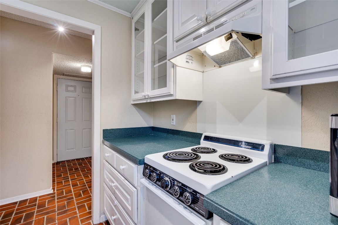 2110 Rio Grande Street, Unit 208 Austin, TX 78705 - Photo 20 of 31 a kitchen with a stove and white cabinets