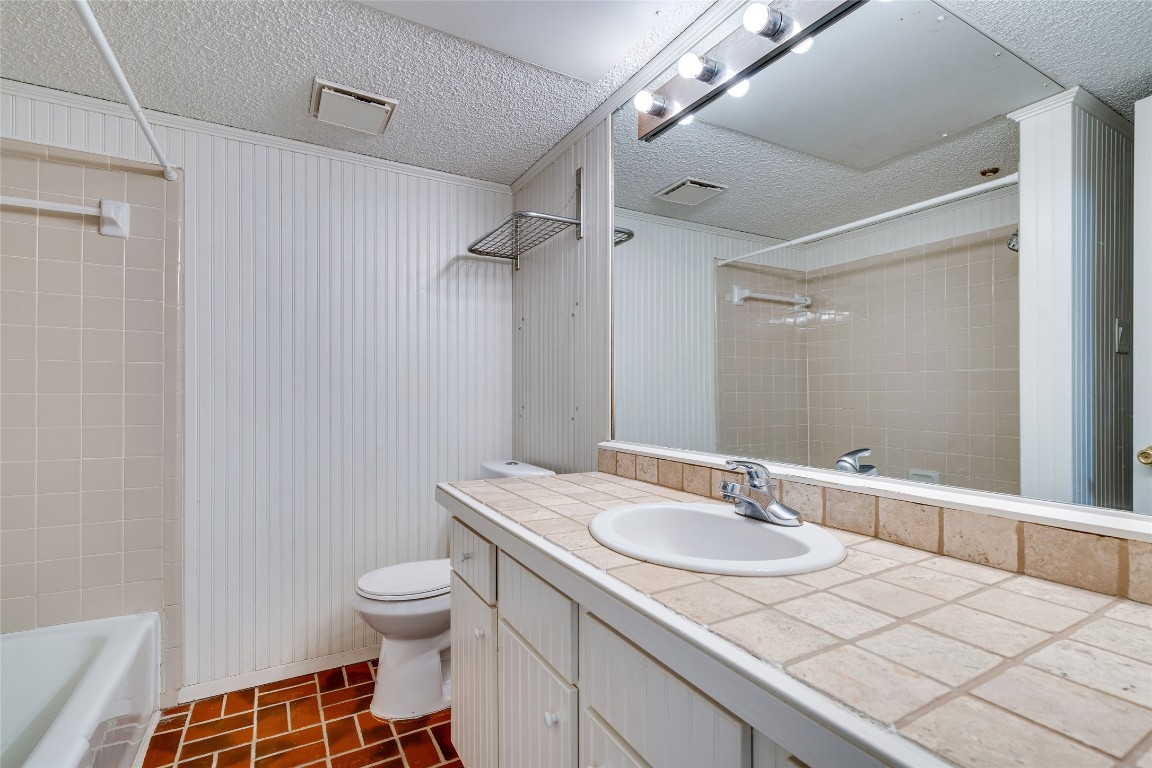 2110 Rio Grande Street, Unit 208 Austin, TX 78705 - Photo 29 of 31 a bathroom with a granite countertop sink a toilet and a mirror