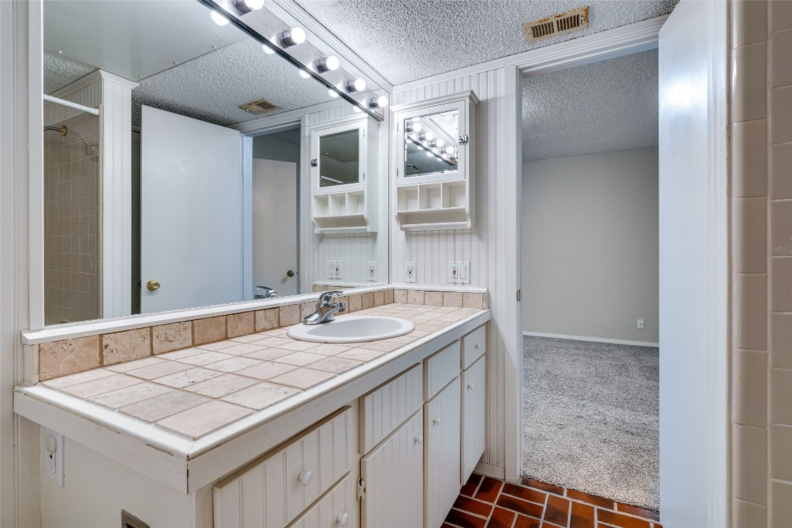 2110 Rio Grande Street, Unit 208 Austin, TX 78705 - Photo 31 of 31 a bathroom with a granite countertop sink and a mirror