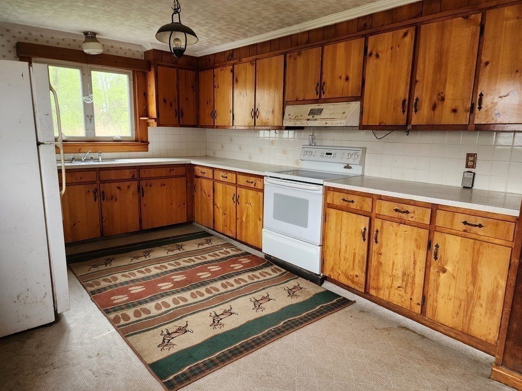 6 Mougin Road Cummington, MA 01026 - Photo 7 of 26 a kitchen with wooden cabinets stove and a granite counter top